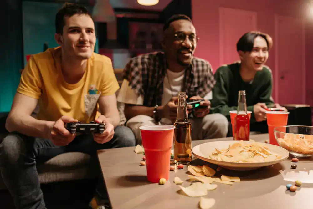 Four friends sitting on a sofa cheering and playing a vibrant party game