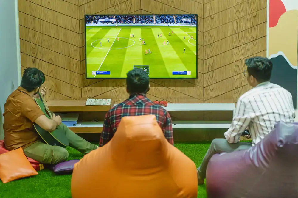 Players laughing while playing a Couchstorm game on a TV screen